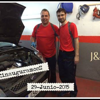 Jose y su compañero, los mecánicos de J&H Taller Multimarca, junto a un coche en el taller el día de la inauguración en 2015